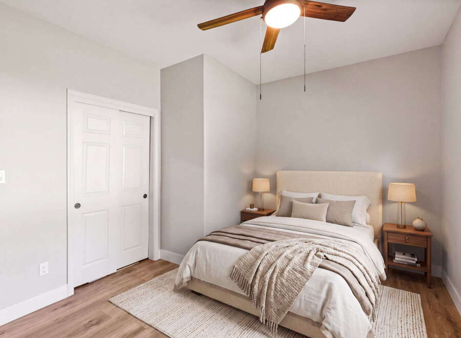 Discover this inviting bedroom featuring a plush bed adorned with neutral-toned linens and a cozy throw blanket.