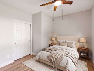 Discover this inviting bedroom featuring a plush bed adorned with neutral-toned linens and a cozy throw blanket.