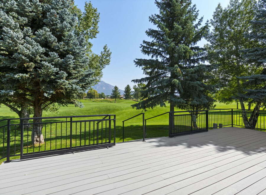 Enjoy breathtaking views from this expansive deck overlooking a pristine golf course.