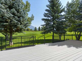 Enjoy breathtaking views from this expansive deck overlooking a pristine golf course.