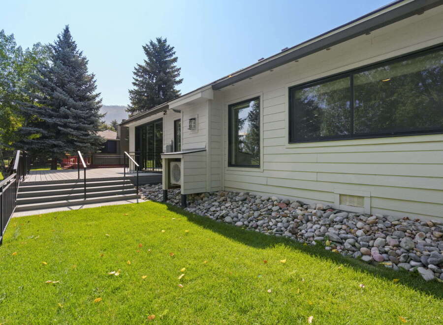 This modern home features a spacious deck with black railings, perfect for outdoor entertaining.