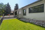This modern home features a spacious deck with black railings, perfect for outdoor entertaining.