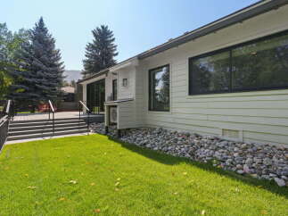 This modern home features a spacious deck with black railings, perfect for outdoor entertaining.