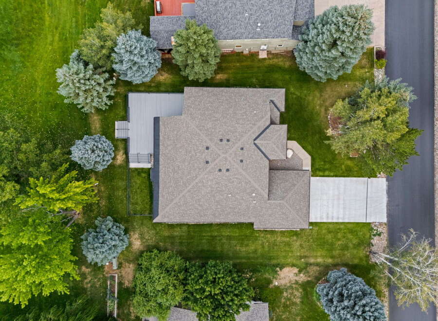 Discover this stunning property from an aerial perspective, showcasing a beautifully maintained home with a spacious deck perfect for outdoor living.