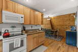 This charming kitchen features warm, natural wood cabinetry and a sleek white microwave.