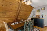 Experience rustic charm in this dining area, featuring a warm wooden table adorned with a decorative runner and pinecones.
