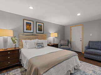 Experience cozy comfort in this charming bedroom, featuring a rustic wooden headboard and plush bedding.