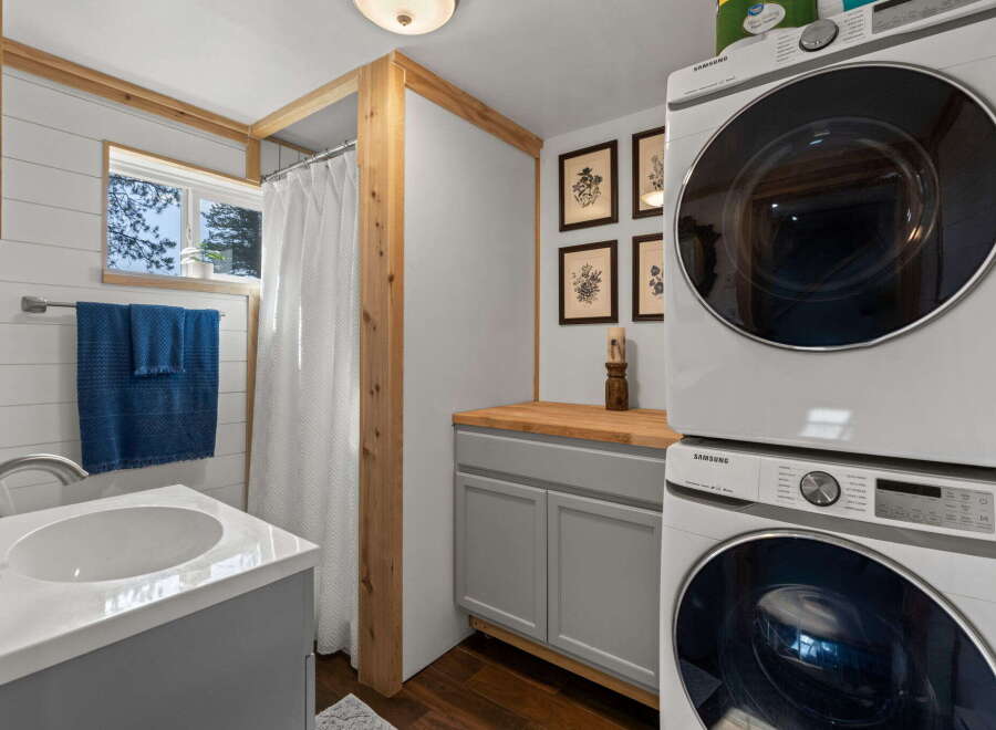 This compact bathroom features a space-saving stacked Samsung washer and dryer, perfect for small living spaces.