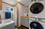 This compact bathroom features a space-saving stacked Samsung washer and dryer, perfect for small living spaces.