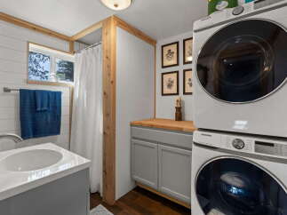 This compact bathroom features a space-saving stacked Samsung washer and dryer, perfect for small living spaces.