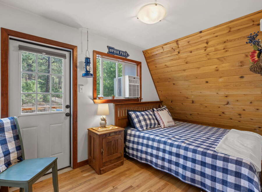 Cozy bedroom featuring a comfortable bed with blue and white gingham bedding and a matching throw pillow.