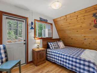 Cozy bedroom featuring a comfortable bed with blue and white gingham bedding and a matching throw pillow.