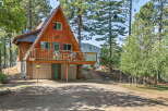 Discover this charming A-frame cabin nestled among tall pine trees, offering a serene mountain retreat.