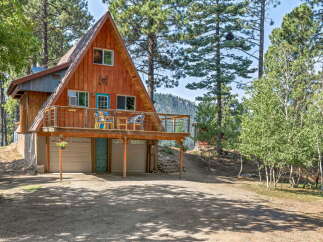 Discover this charming A-frame cabin nestled among tall pine trees, offering a serene mountain retreat.