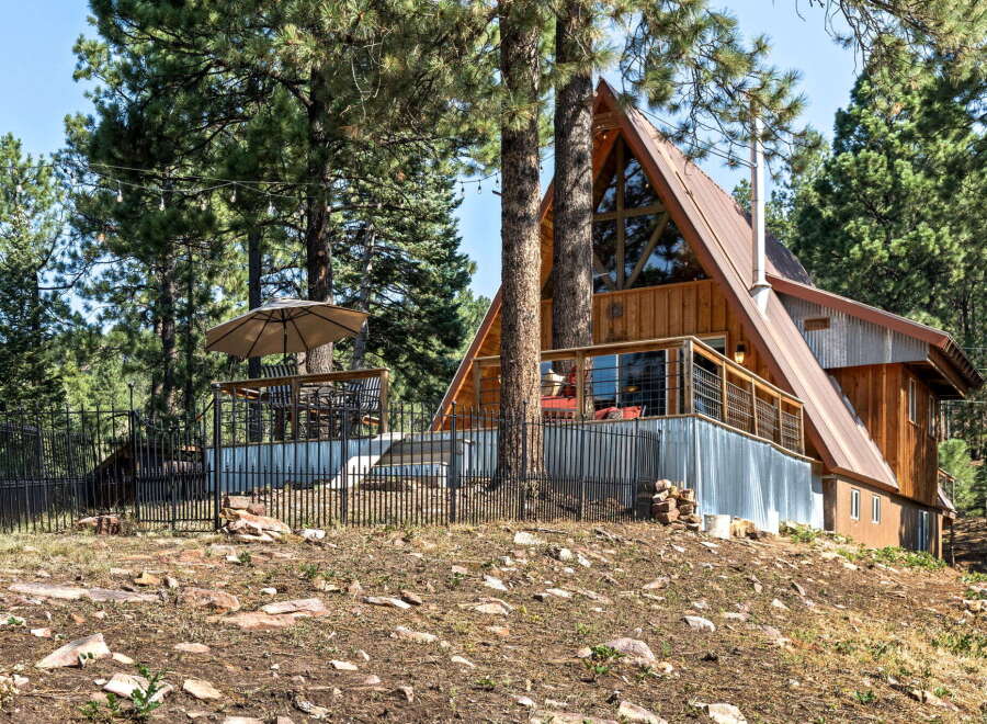 Experience the charm of this A-frame cabin nestled amongst tall pine trees.