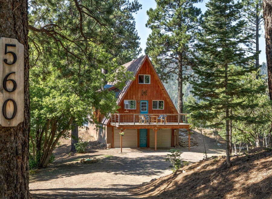 Nestled amidst tall pines, this charming A-frame cabin offers a serene mountain retreat.