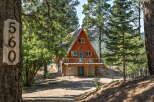 Nestled amidst tall pines, this charming A-frame cabin offers a serene mountain retreat.