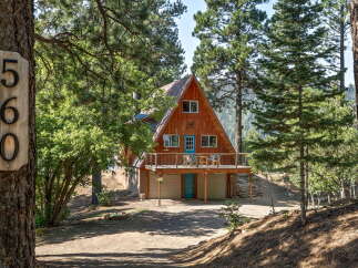 Nestled amidst tall pines, this charming A-frame cabin offers a serene mountain retreat.