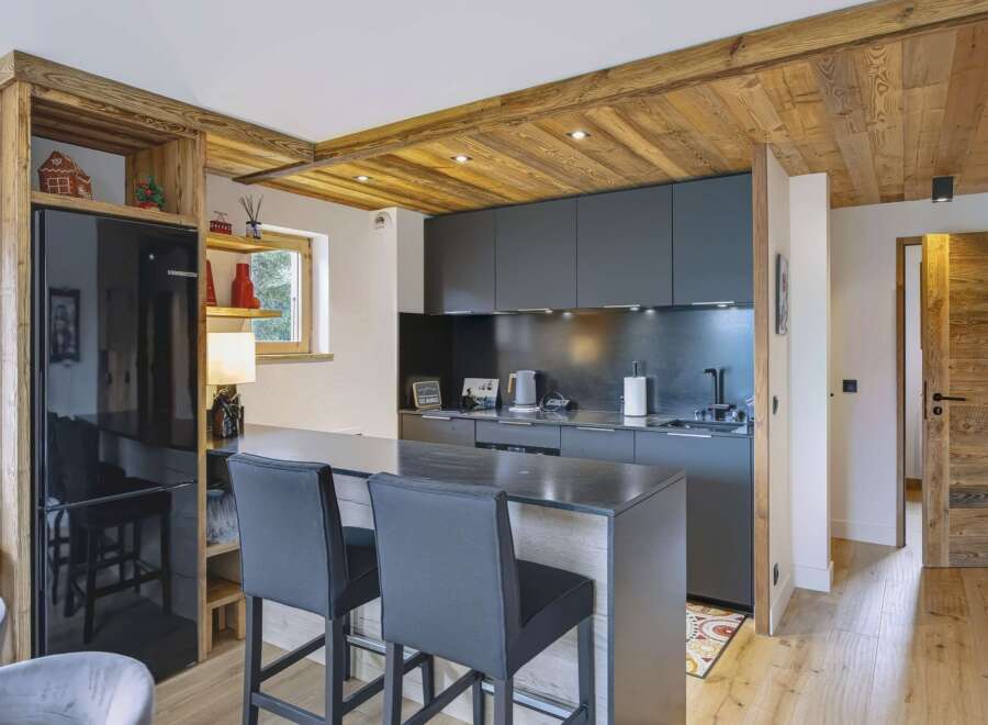 Experience modern alpine living in this stunning kitchen featuring sleek dark cabinetry and a spacious island with bar seating.