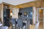 Experience modern alpine living in this stunning kitchen featuring sleek dark cabinetry and a spacious island with bar seating.