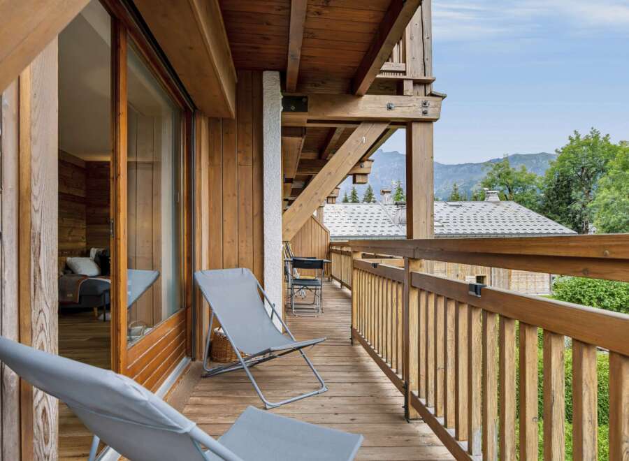 Enjoy breathtaking mountain views from this charming wooden balcony, perfect for relaxing with a morning coffee or evening drink.