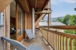 Enjoy breathtaking mountain views from this charming wooden balcony, perfect for relaxing with a morning coffee or evening drink.
