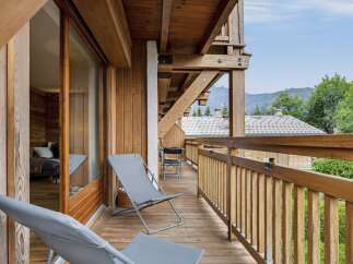 Enjoy breathtaking mountain views from this charming wooden balcony, perfect for relaxing with a morning coffee or evening drink.