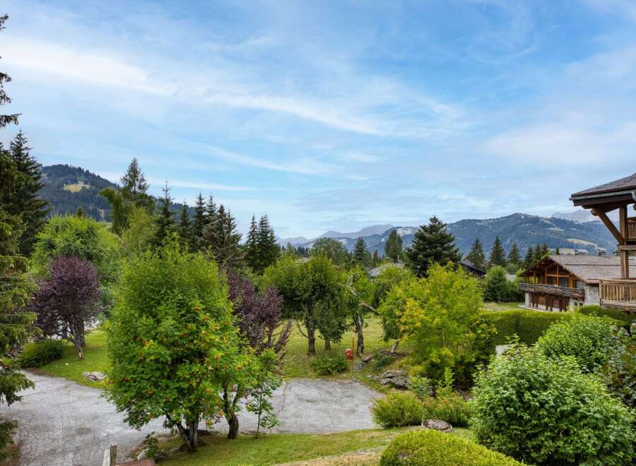 Experience the charm of alpine living with this stunning property nestled amidst lush greenery and majestic mountains.