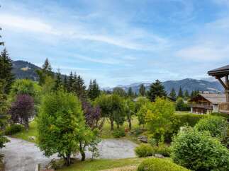 Experience the charm of alpine living with this stunning property nestled amidst lush greenery and majestic mountains.
