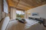 Experience ultimate comfort in this luxurious bedroom, featuring a plush bed and stunning mountain views from the private balcony.