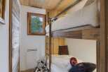 This charming room features cozy bunk beds with plush white bedding, perfect for a family or guests.
