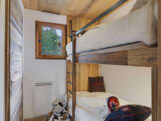 This charming room features cozy bunk beds with plush white bedding, perfect for a family or guests.