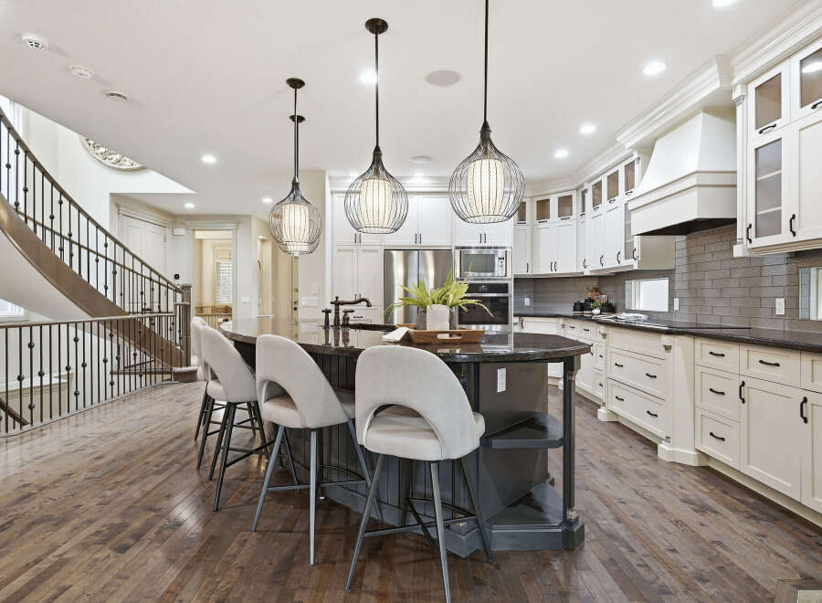 Experience luxury in this stunning gourmet kitchen, featuring a spacious island with seating and elegant pendant lighting.