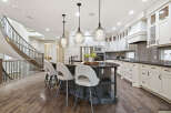 Experience luxury in this stunning gourmet kitchen, featuring a spacious island with seating and elegant pendant lighting.
