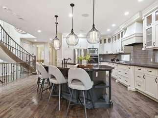 Experience luxury in this stunning gourmet kitchen, featuring a spacious island with seating and elegant pendant lighting.