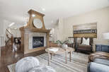 Step into this inviting living space featuring a grand wooden fireplace as the centerpiece, perfect for cozy evenings.