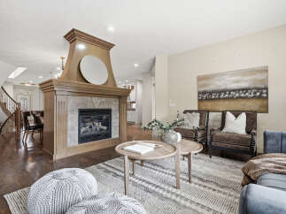 Step into this inviting living space featuring a grand wooden fireplace as the centerpiece, perfect for cozy evenings.