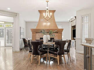 Experience elegant dining in this beautifully appointed space, featuring a round dining table with plush leather chairs perfect for hosting.