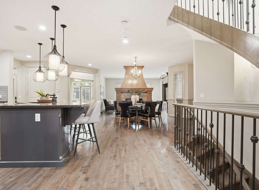 Experience luxury living in this stunning open-concept home, featuring a gourmet kitchen with a large island and pendant lighting, perfect for entertaining.