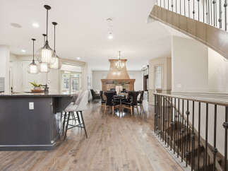 Experience luxury living in this stunning open-concept home, featuring a gourmet kitchen with a large island and pendant lighting, perfect for entertaining.