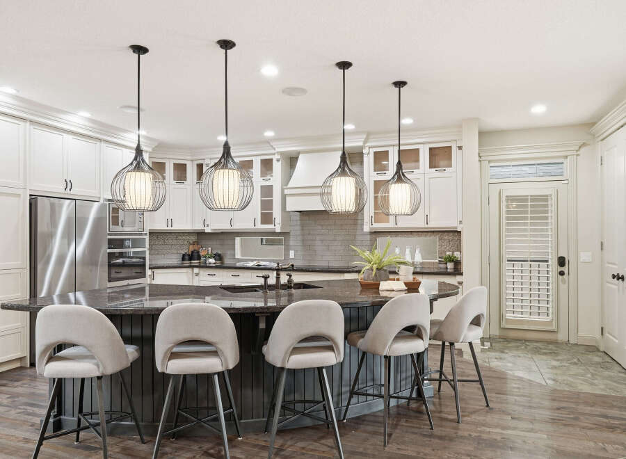 Experience luxury in this stunning kitchen, featuring a large granite island with comfortable bar seating, perfect for entertaining.