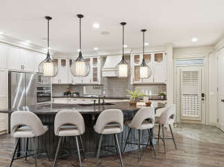 Experience luxury in this stunning kitchen, featuring a large granite island with comfortable bar seating, perfect for entertaining.