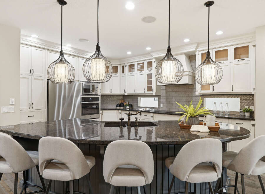 Experience luxury in this stunning kitchen, featuring a large granite island perfect for entertaining and a sleek, modern design.
