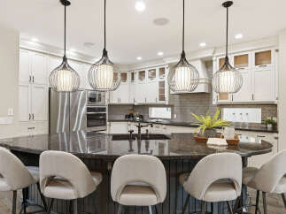 Experience luxury in this stunning kitchen, featuring a large granite island perfect for entertaining and a sleek, modern design.