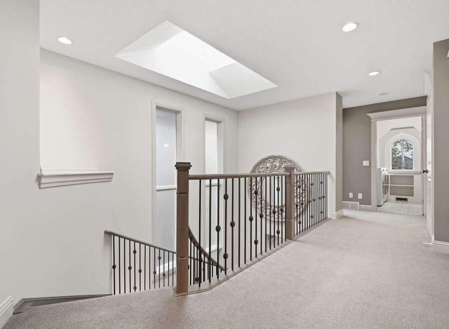 This spacious hallway features a beautiful skylight that floods the area with natural light.