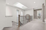This spacious hallway features a beautiful skylight that floods the area with natural light.