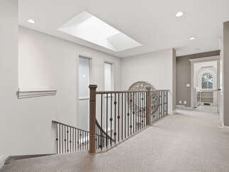 This spacious hallway features a beautiful skylight that floods the area with natural light.