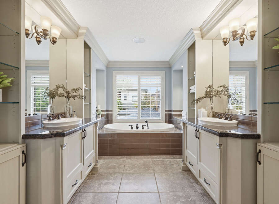 Indulge in luxury in this stunning master bathroom, featuring dual vanities with granite countertops and elegant undermount sinks.