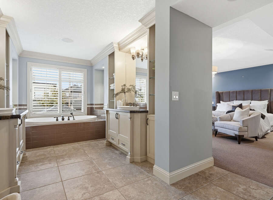 Experience luxury in this master suite featuring a spa-like bathroom with a soaking tub and dual vanities.