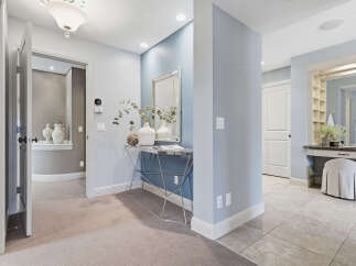 Step into this elegant hallway featuring a striking blue accent wall adorned with a decorative mirror and console table.